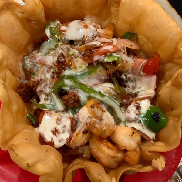 Tulum Fresh Mexican Grill's taco salad with shrimp, ground beef, vegetables, and crema in a tortilla bowl.